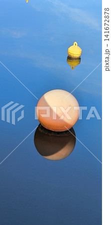 Floats in calm weather against the background of blue water Floats in calm weather against the background of blue water 141672878