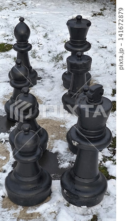 Large outdoor chess pieces on the snow in a park 141672879