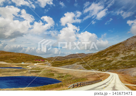 Driving a car on mountain road. Nature Norway. Polar circle. The way to Nordkapp Driving a car on mountain road. Nature Norway. Polar circle. The way to Nordkapp 141673471