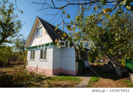 Small country house with a plot. Typical houses given in the post-Soviet space. Small country house with a plot. Typical houses given in the post-Soviet space. 141675052
