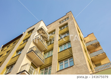 Building facade with balconies against clear blue sky 141675079