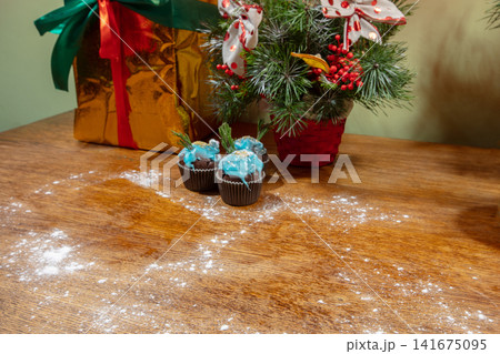Decorative treats, gift box, and floral arrangement on wooden table for festive celebration 141675095