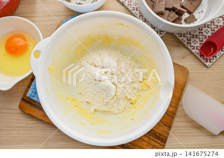ボウルで混ぜたバターと砂糖に粉物を加える ボウルで混ぜたバターと砂糖に粉物を加える 141675274
