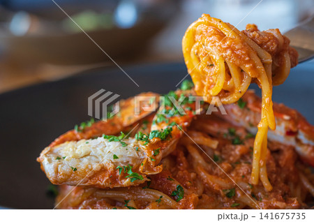 カニのトマトソースパスタをフォークで持ち上げる様子 カニのトマトソースパスタをフォークで持ち上げる様子 141675735