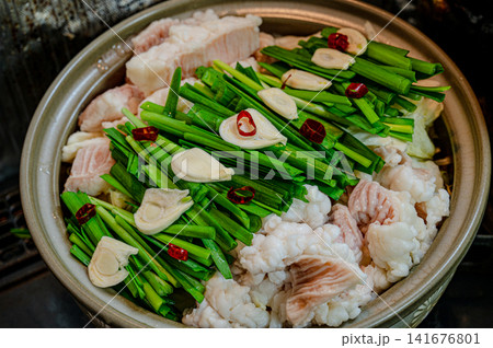 もつ鍋の具材、ニラとにんにくが彩る土鍋料理 もつ鍋の具材、ニラとにんにくが彩る土鍋料理 141676801