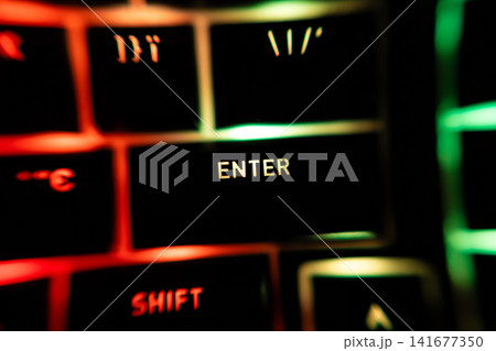 Macro close-up of illuminated Enter and Shift keys on a RGB backlit keyboard, highlighting colorful lighting, modern computing, gaming hardware and digital technology workspace Macro close-up of illuminated Enter and Shift keys on a RGB backlit keyboard, highlighting colorful lighting, modern computing, gaming hardware and digital technology workspace 141677350