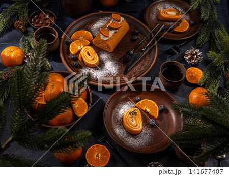 Holiday dessert roll with tangerines and festive decor Holiday dessert roll with tangerines and festive decor 141677407