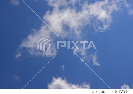 Soft wispy white clouds scattered gracefully across a bright blue summer sky. High Quality Photo Soft wispy white clouds scattered gracefully across a bright blue summer sky. High Quality Photo 141677592