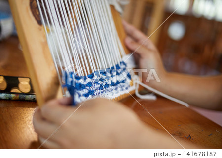 Weaving on a loom frame 141678187