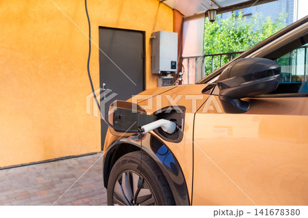 Close up of electric vehicle charging in driveway Close up of electric vehicle charging in driveway 141678380