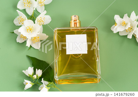 luxury perfume bottle with jasmine flowers on green background luxury perfume bottle with jasmine flowers on green background 141679260