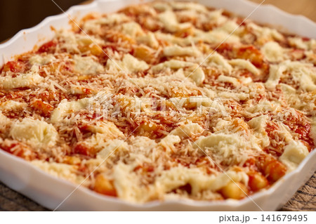 Gnocchi topped with tomato sauce, mozzarella and cheese in ceramic baking dish Gnocchi topped with tomato sauce, mozzarella and cheese in ceramic baking dish 141679495
