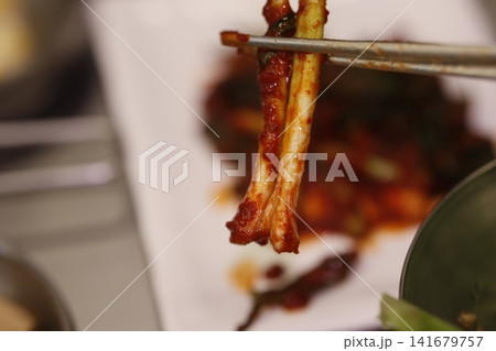 Spicy Korean Food on Chopsticks Close-up Spicy Korean Food on Chopsticks Close-up 141679757