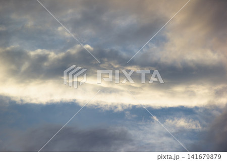 Dramatic dark storm clouds catching golden warm sunlight during sunset Dramatic dark storm clouds catching golden warm sunlight during sunset 141679879