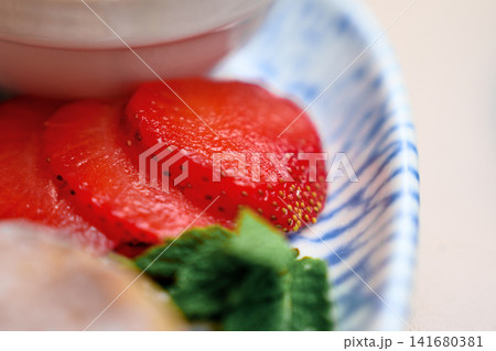 Juicy red strawberry slices arranged on a blue and white patterned ceramic plate Juicy red strawberry slices arranged on a blue and white patterned ceramic plate 141680381