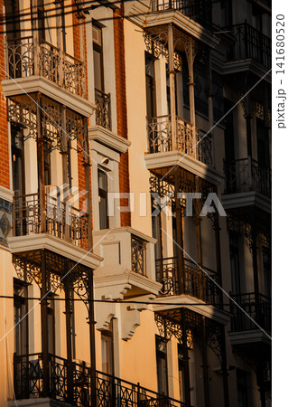 Elegant Residential Building Facade with Ornate Iron Balconies in Golden Hour Light, Architectural Elegant Residential Building Facade with Ornate Iron Balconies in Golden Hour Light, Architectural 141680520