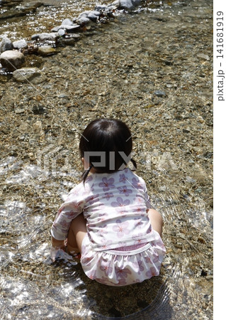 川で水遊びする女の子の後ろ姿。浅い流れと砂利の河原。 川で水遊びする女の子の後ろ姿。浅い流れと砂利の河原。 141681919