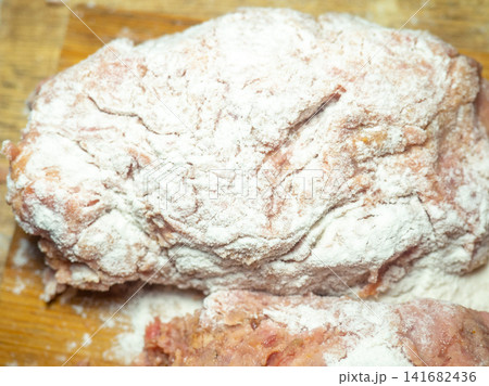 A piece of minced chicken in flour. Meat after the meat grinder. Cooking cutlets. Minced meat close-up. A piece of minced chicken in flour. Meat after the meat grinder. Cooking cutlets. Minced meat close-up. 141682436