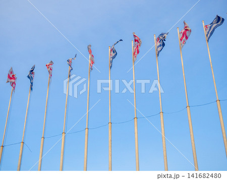 Many flags on flagpoles. Flags in the wind. State symbols Many flags on flagpoles. Flags in the wind. State symbols 141682480