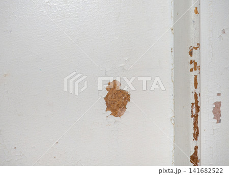 Part of an old door. White paint is coming off the wood. Surface with peeling paint. Part of an old door. White paint is coming off the wood. Surface with peeling paint. 141682522