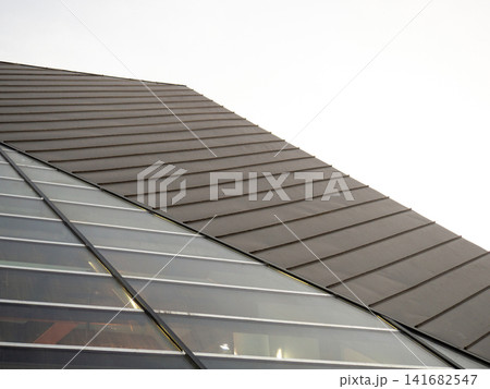 Modern geometric architecture from a special angle. Part of a modern gloomy building. Modern geometric architecture from a special angle. Part of a modern gloomy building. 141682547
