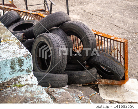 pile of dumped used car tires. Lots of rubber. Tire dump. Industrial zone. Next to the auto repair shop. 141682550