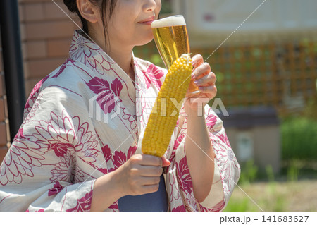 ビールを飲む横顔、とうもろこしを添えて ビールを飲む横顔、とうもろこしを添えて 141683627