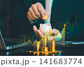 Businessman putting coin into piggy bank with rising stock graph overlay and stacks of gold coins, investment growth and wealth planning concept. 141683774