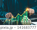 Businessman touching rising growth graph percentage overlay with gold bullion bars and coin stacks, gold investment and wealth growth concept. 141683777