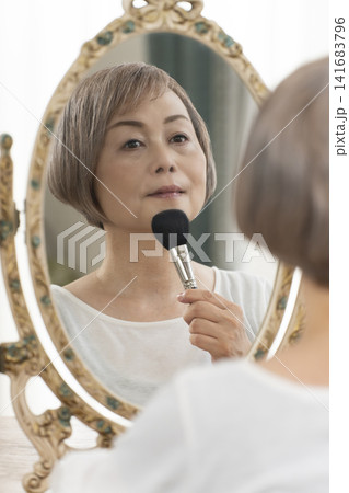 鏡の前でメイクをするシニア女性 141683796