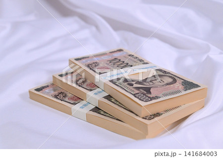 布の上に置かれた1万円の札束 布の上に置かれた1万円の札束 141684003