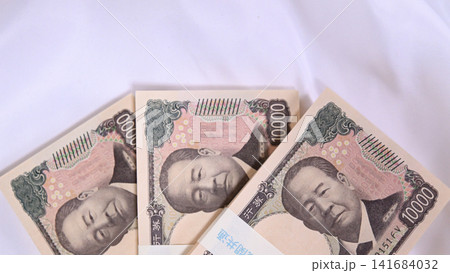 布の上に置かれた1万円の札束 布の上に置かれた1万円の札束 141684032