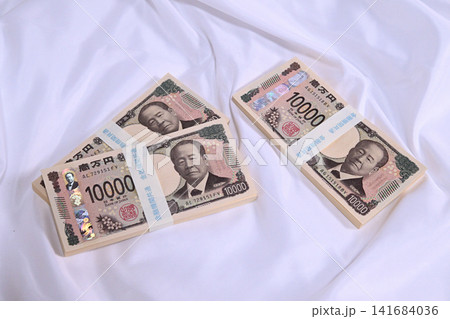 布の上に置かれた1万円の札束 布の上に置かれた1万円の札束 141684036