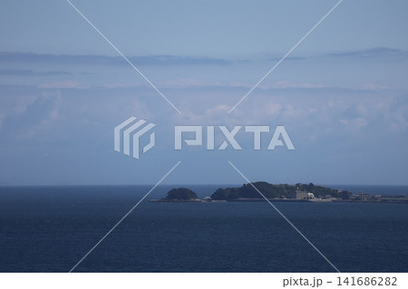 雲と青空と水平線と青い海面の海と建物のある島の風景 141686282