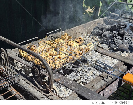 Marinated button mushrooms roasting on barbecue grill with smoky flavor and crispy caramelized surface Marinated button mushrooms roasting on barbecue grill with smoky flavor and crispy caramelized surface 141686495
