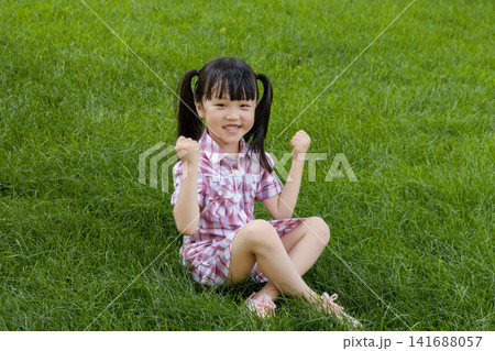 Happy Asian Little Girl Playing on Green Grass in Summer Park 141688057