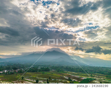 Aerial view of Sapa rice terraces at sunrise with golden light over green fields and misty mountain valleys 141688190