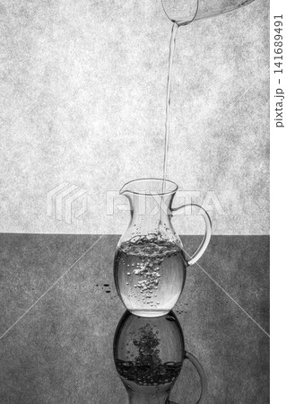 Pouring water into a glass decanter Pouring water into a glass decanter 141689491