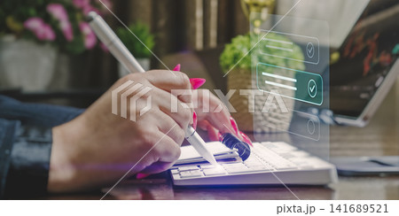 Digital task management and productivity concept. Businesswoman completing virtual checklist with glowing stylus pen. 141689521