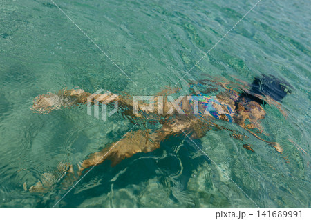 Girl Swimming in Transparent Seawater Viewed from Above Girl Swimming in Transparent Seawater Viewed from Above 141689991