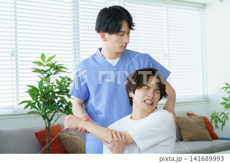 施術をする若い日本人男性整体師と痛がる若い日本人の男性患者 施術をする若い日本人男性整体師と痛がる若い日本人の男性患者 141689993