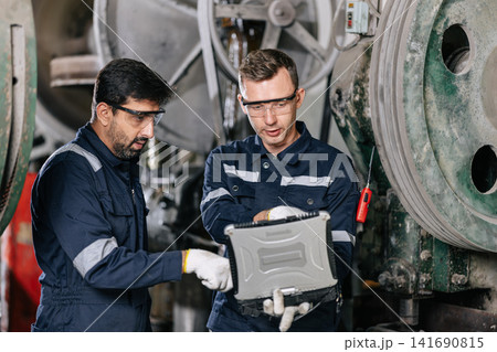 Professional Engineer workers monitor at laptop computer service machine in heavy industry factory Professional Engineer workers monitor at laptop computer service machine in heavy industry factory 141690815