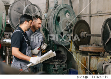 Engineer male workers team working together service maintenance machine in workshop, Heavy industry. Engineer male workers team working together service maintenance machine in workshop, Heavy industry. 141690819