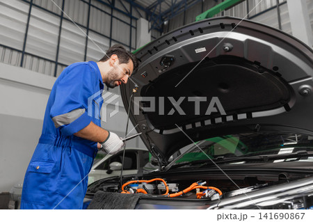 Professional EV Car Service, Male workers Electricity Vehicle Fix Maintenance in EV Garage workshop. Professional EV Car Service, Male workers Electricity Vehicle Fix Maintenance in EV Garage workshop. 141690867