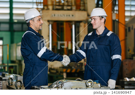 Lead senior engineer worker hand shaking with young man for deal success job in die casting plant Lead senior engineer worker hand shaking with young man for deal success job in die casting plant 141690947