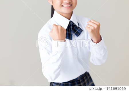ガッツポーズをする制服姿の中学生の女の子・グレーバック ガッツポーズをする制服姿の中学生の女の子・グレーバック 141691069