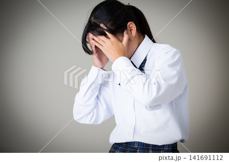 落ち込む制服姿の中学生の女の子・グレーバック 落ち込む制服姿の中学生の女の子・グレーバック 141691112