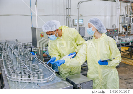 Food industry people worker, Quality control staff inspecting cannery food product in production line conveyor belt in food factory plant. Food industry people worker, Quality control staff inspecting cannery food product in production line conveyor belt in food factory plant. 141691167
