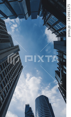 looking up perspective of modern high-rise skyscraper towerr with glass corporate architecture, futuristic urban skyline with towering highrise buildings and geometric city facade background looking up perspective of modern high-rise skyscraper towerr with glass corporate architecture, futuristic urban skyline with towering highrise buildings and geometric city facade background 141691175