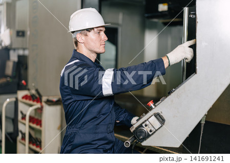 Professional engineer Caucasian male worker control operate CNC Machine in industry metal factory Professional engineer Caucasian male worker control operate CNC Machine in industry metal factory 141691241